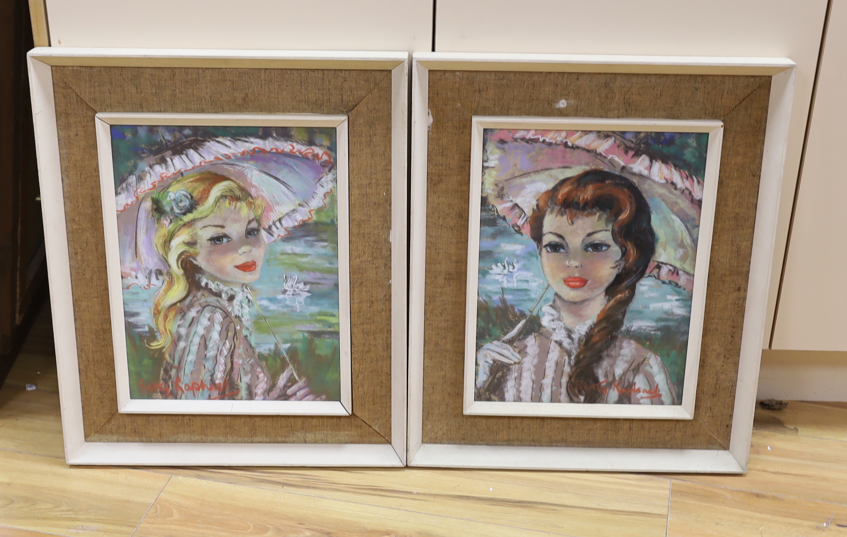 Betty Raphael (20th.C), pair of pastels, Portraits of young women holding parasols, each signed, 40 x 30cm